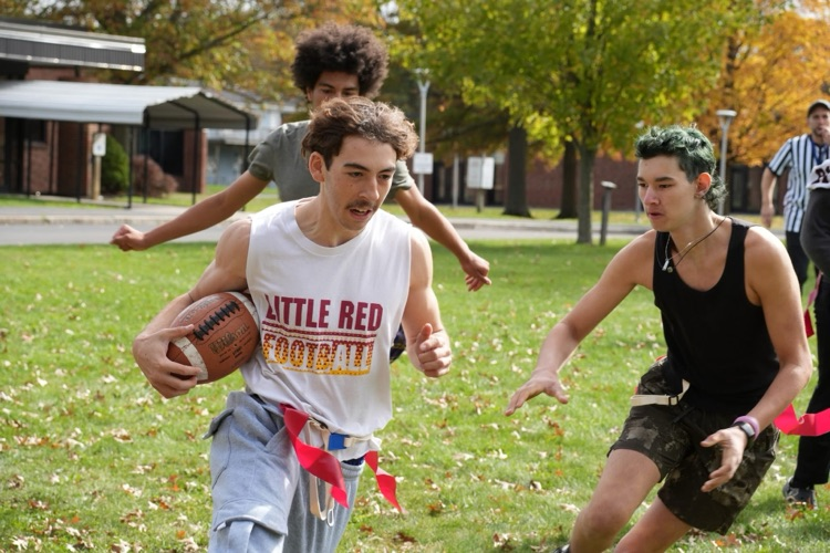 student running and carrying ball