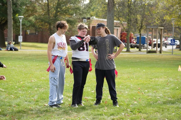 three students going over play in football
