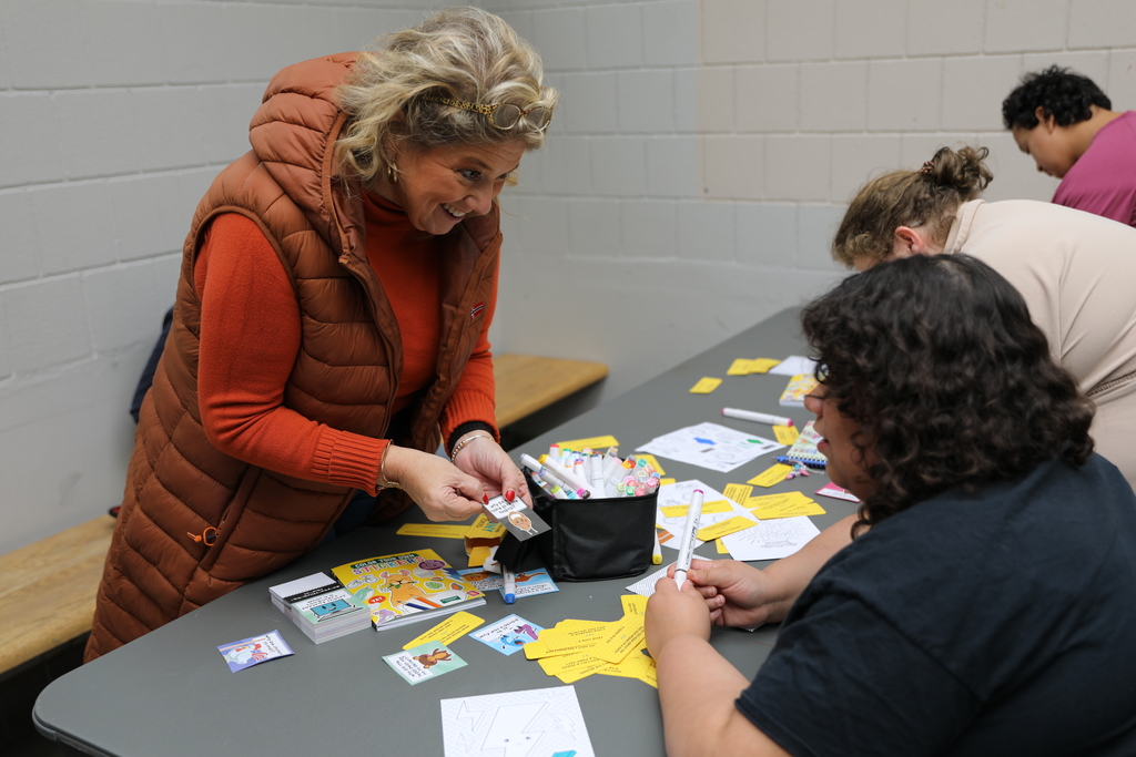 A student and an adult playing a game with cards and drawings