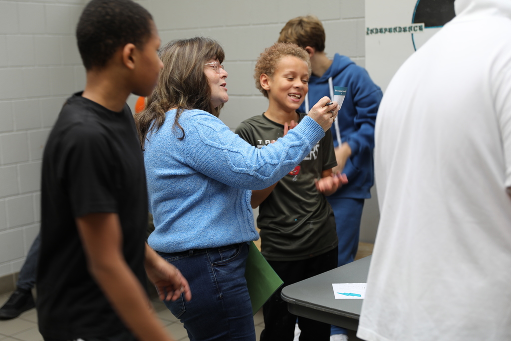 a student and an adult playing a game with a card