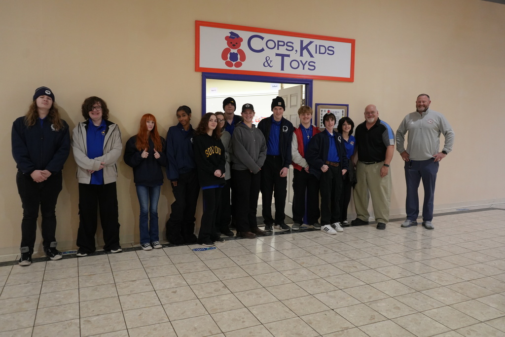 a group of students posing for a photo outside of Cops, Kids, and Toys