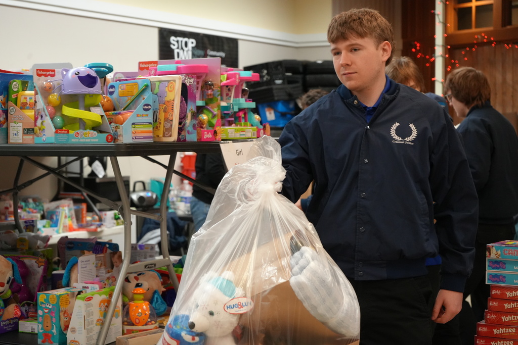 A student walking his bag of gifts to the storage area