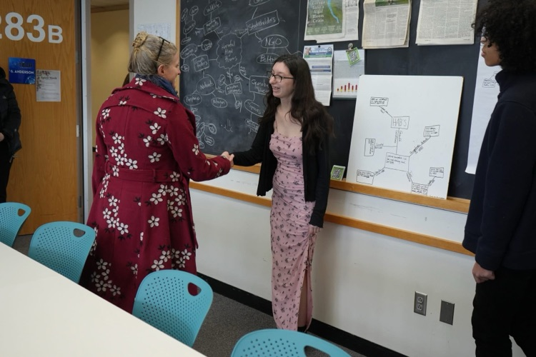 Anna Kelles visits ptech students to discuss HABs. this image shows a student shaking Anna’s hand  