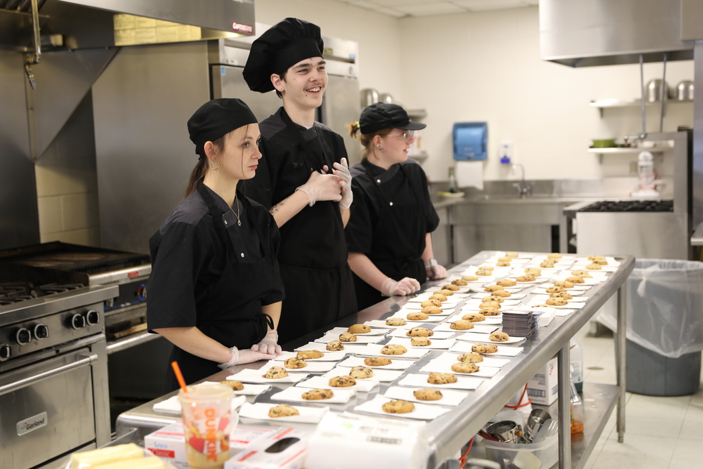 three current students presenting cookies