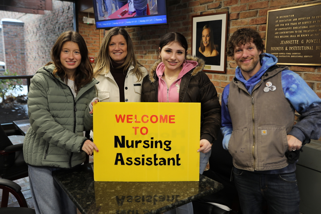 Current students and faculty holding up a sign