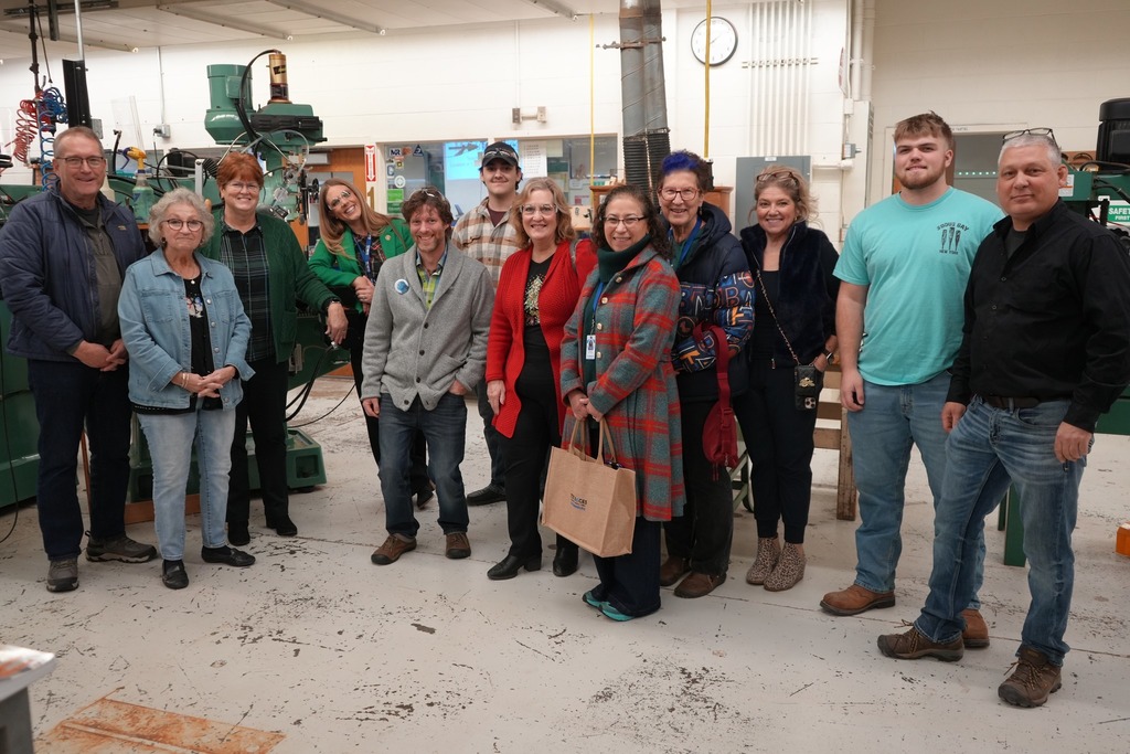 Board of Education members, administrators, instructors, and students stand together inside the CTE Machining and Manufacturing shop at Candor High School.