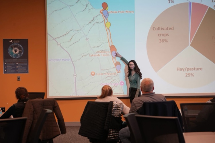 student presenting her HABs solution pointing to a map of locations selected