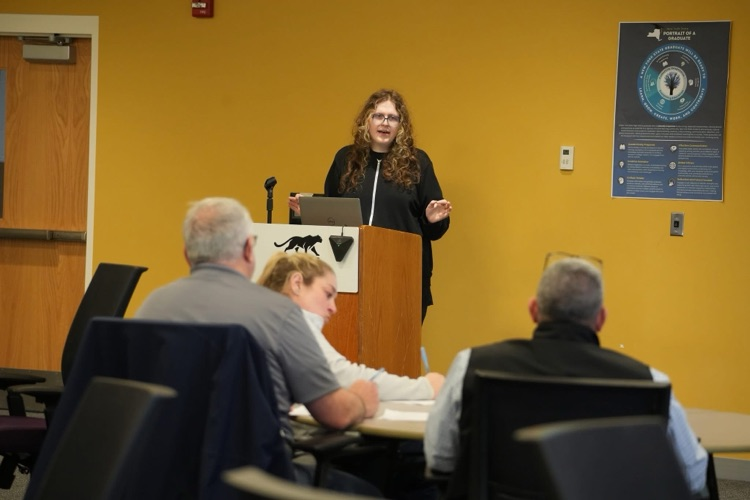 Student presenting at podium with slide about HABs