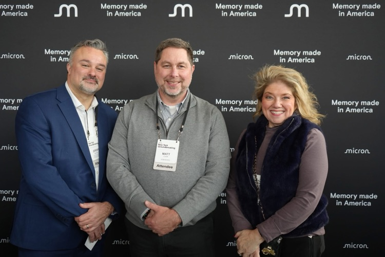 Three education leaders pose together in front of a Micron “Memory Made in America” backdrop during the Micron New York groundbreaking event.
