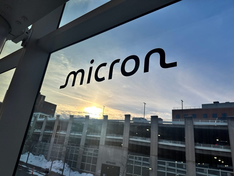 The Micron logo appears on a window overlooking an outdoor parking structure at sunset near the event venue.