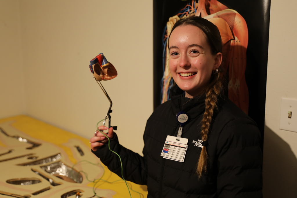a student holding up a mock piece of heart