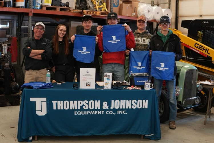 Heavy Equipment students meet with industry partners while equipment and tools are visible in the classroom.