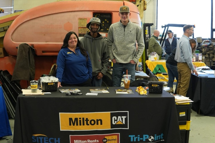 Heavy Equipment students meet with industry partners while equipment and tools are visible in the classroom.