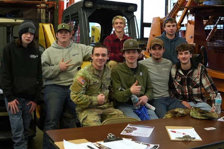 Heavy Equipment students meet with industry partners while equipment and tools are visible in the classroom.