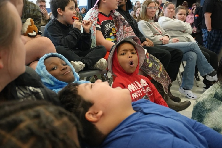 students in crowd react to pied staff member with looks of shock 