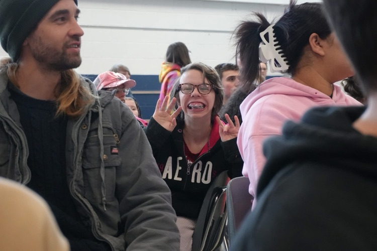 student smiles toward camera in sea of people in the crowd 