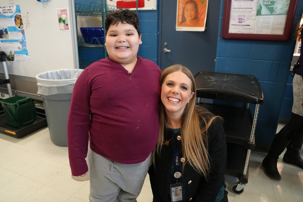 A smiling student stands next to Lily Talcott during lunch with the BOE