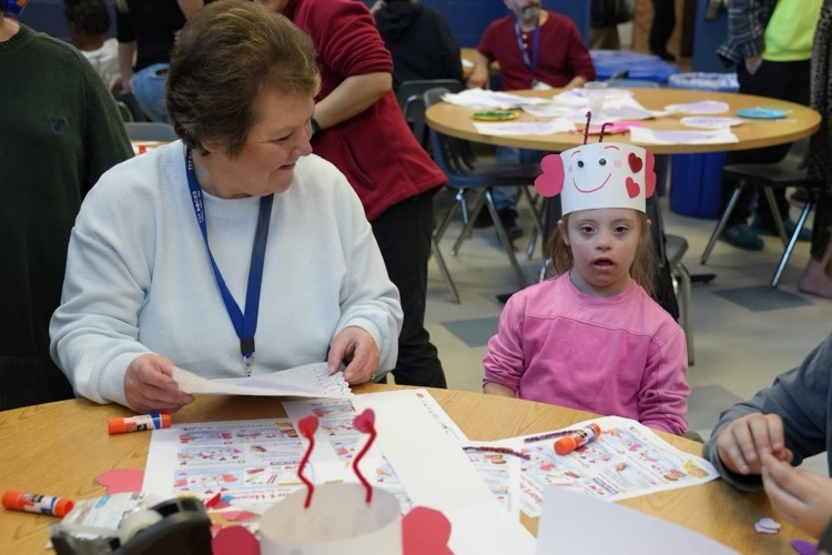 student and staff make a craft together that is valentines day inspired