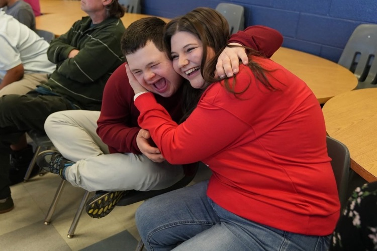   student hugs a staff member in happiness with big smiles at the dance