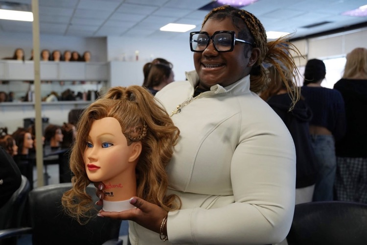   A student shows off a heart inspired hairstyle created during a Cosmetology class Valentine project.