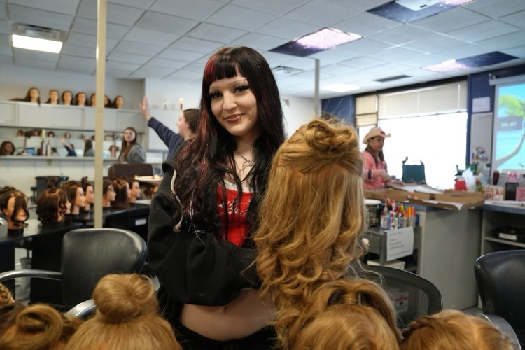  A student shows off a heart inspired hairstyle created during a Cosmetology class Valentine project.