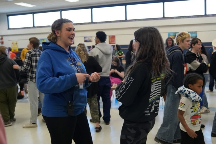 a student and a staff member smile at each other mid singing and dancing at the st. partick’s day dance