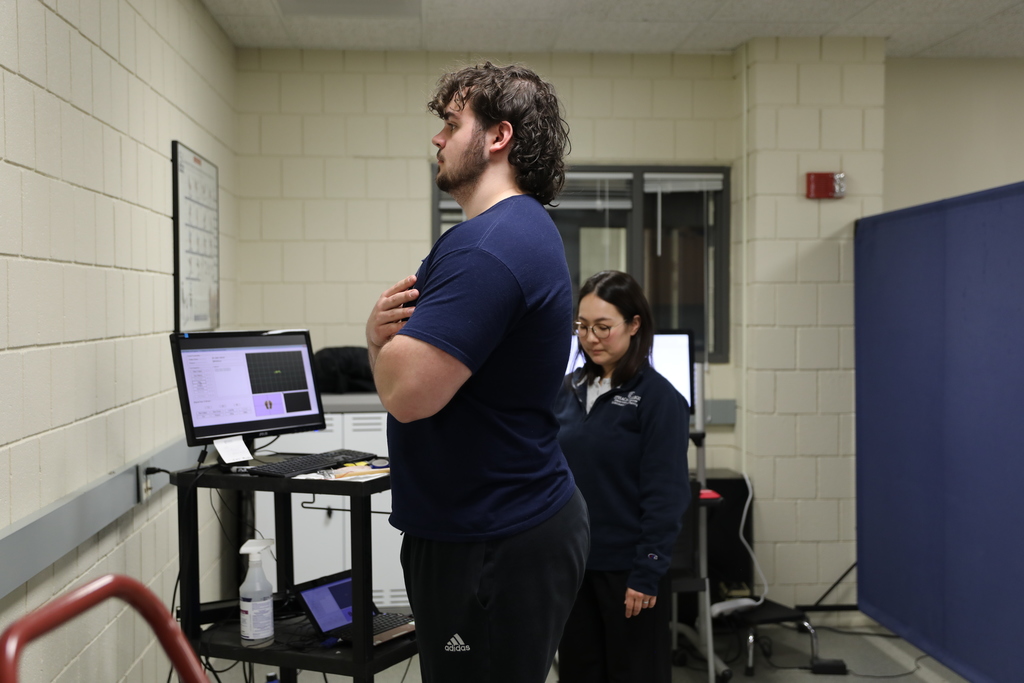 A student does a brain teaser as he standing on one foot