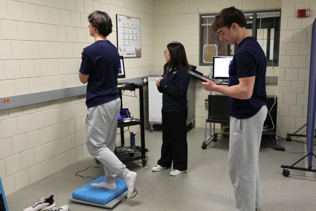 a student standing on one foot while he does a brain teaser