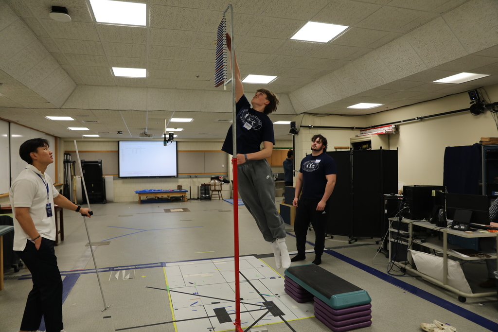 A student jumping into the air to measure their force strength