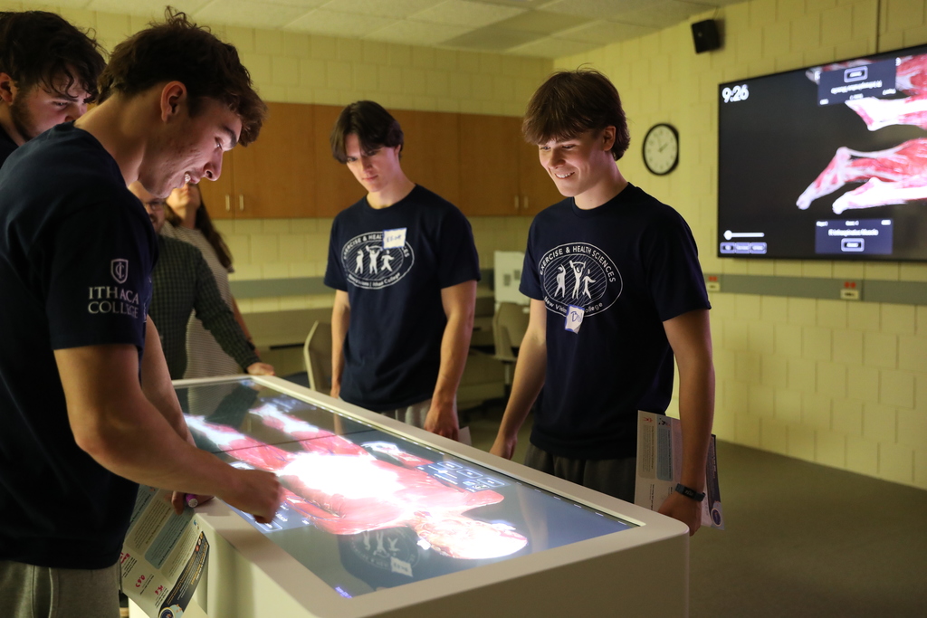 a group of students are looking at the digital screen of the human body