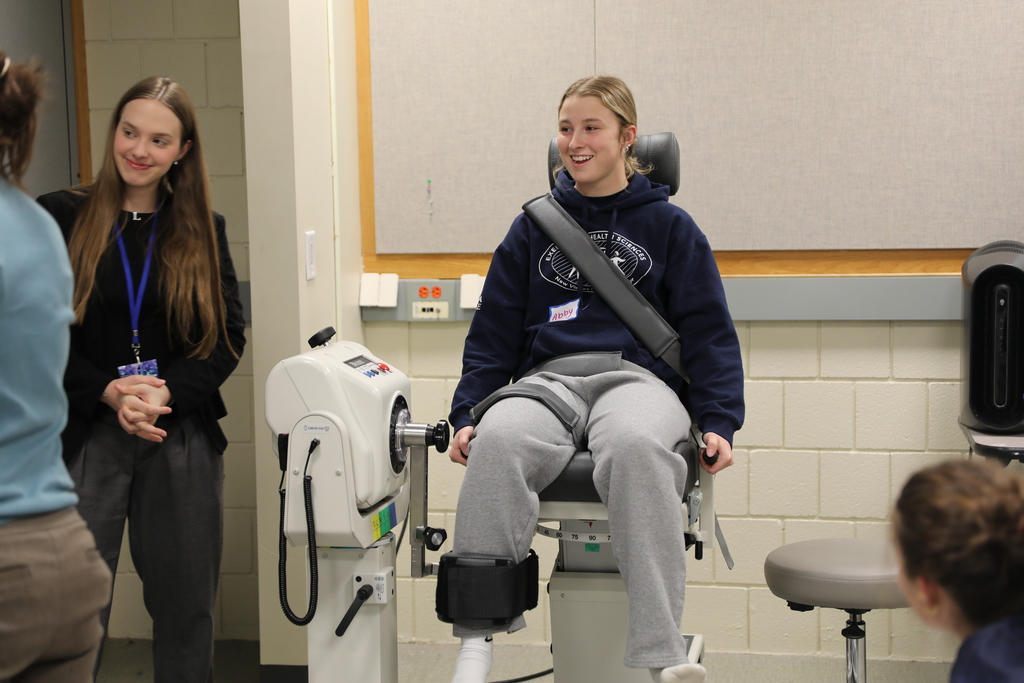 A student gets ready to test leg strength in a custom chair for testing