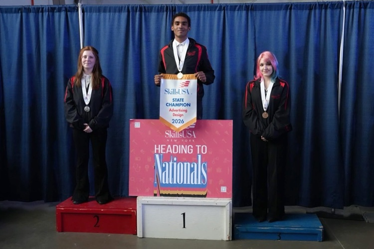 Gold medal winner James Williams III stands on top of a podium holding a sign that reads SKillsUSA State Champion Advertising Design 2026 and a sign below reading SkillsUSA Heading to Nationals
