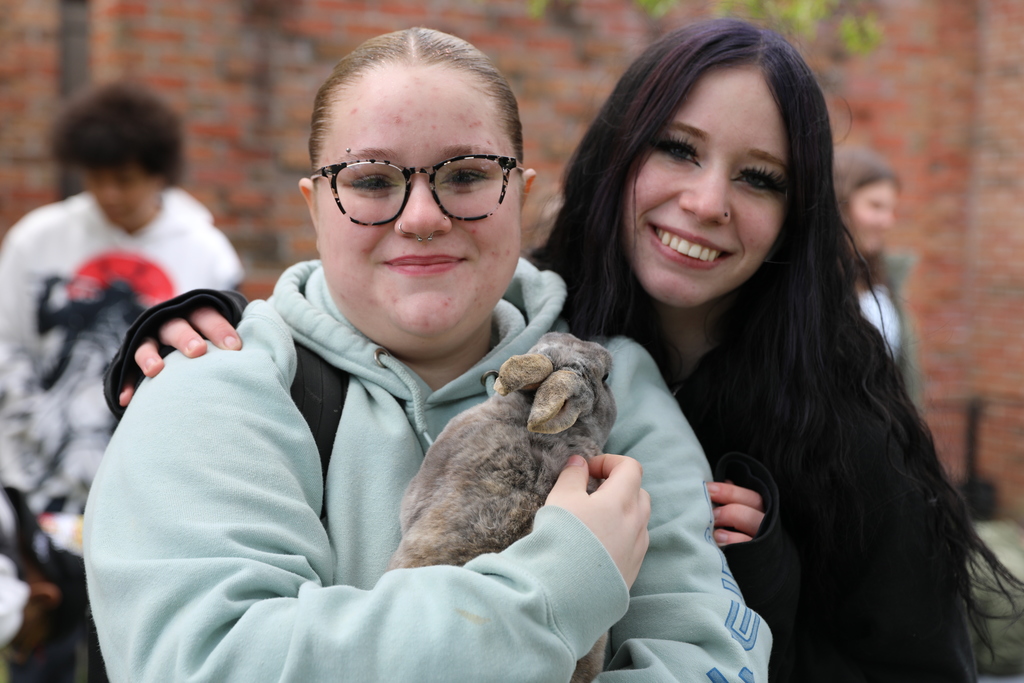 two students posing for a picture with the rabbit