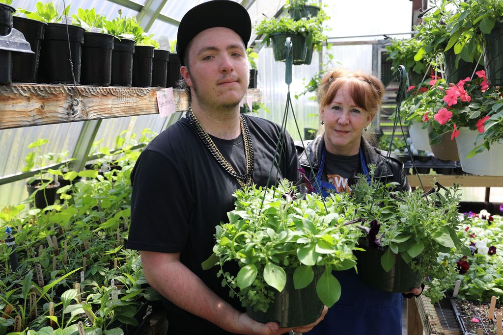 a student holding a plant up to the camera
