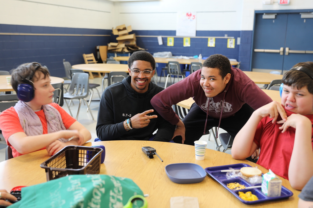 3 students and a staff member posing for the camera