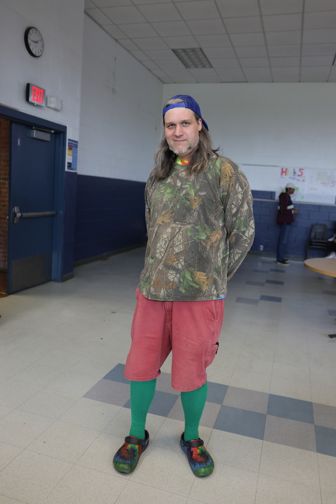 a staff member showing off his red and green outfit