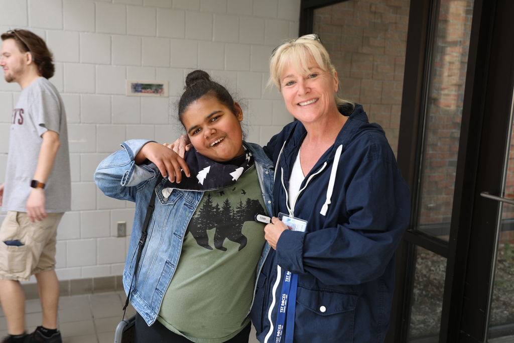 a staff and student posing for a photo