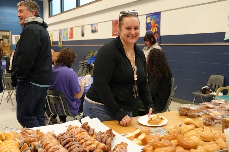 teacher smiles at the pastry table