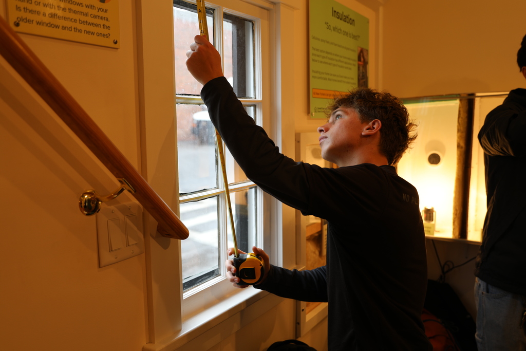 A student measuring the windows in the PowerHouse