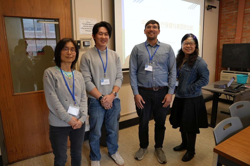 A student participant and three judges pose in front of a presentation screen displaying Chinese text during the Seal of Biliteracy event.