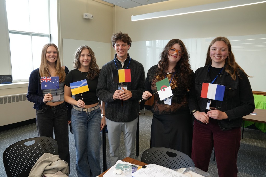 Students from Trumansburg CSD pose together during the Regional Seal of Biliteracy Presentation Day, with several students holding flags representing different languages and cultures.