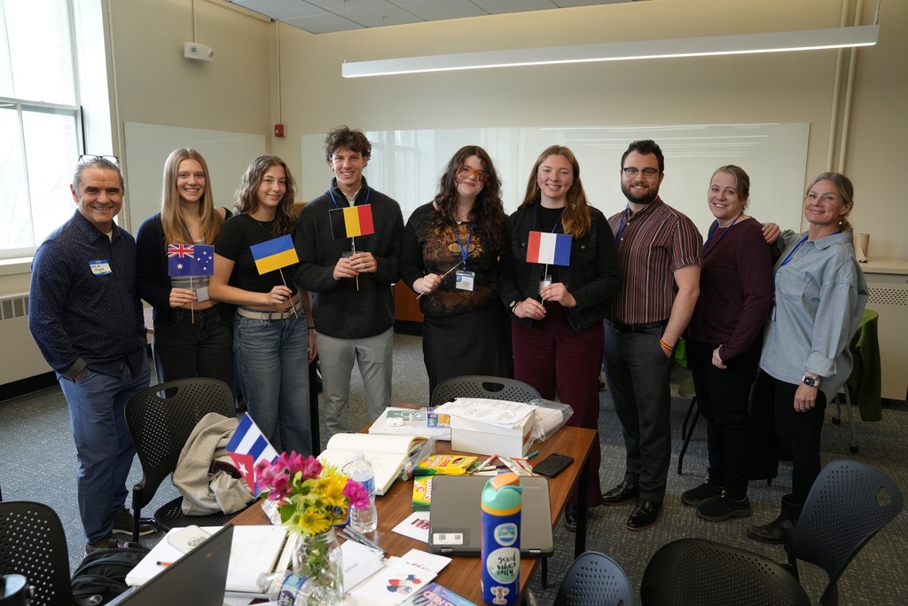 Students from Trumansburg CSD pose together with their teachers during the Regional Seal of Biliteracy Presentation Day, with several students holding flags representing different languages and cultures.