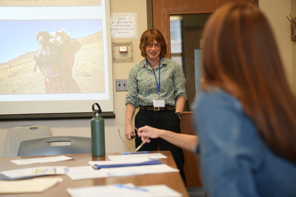 A student gives a presentation while judges listen and review materials during the Regional Seal of Biliteracy event.