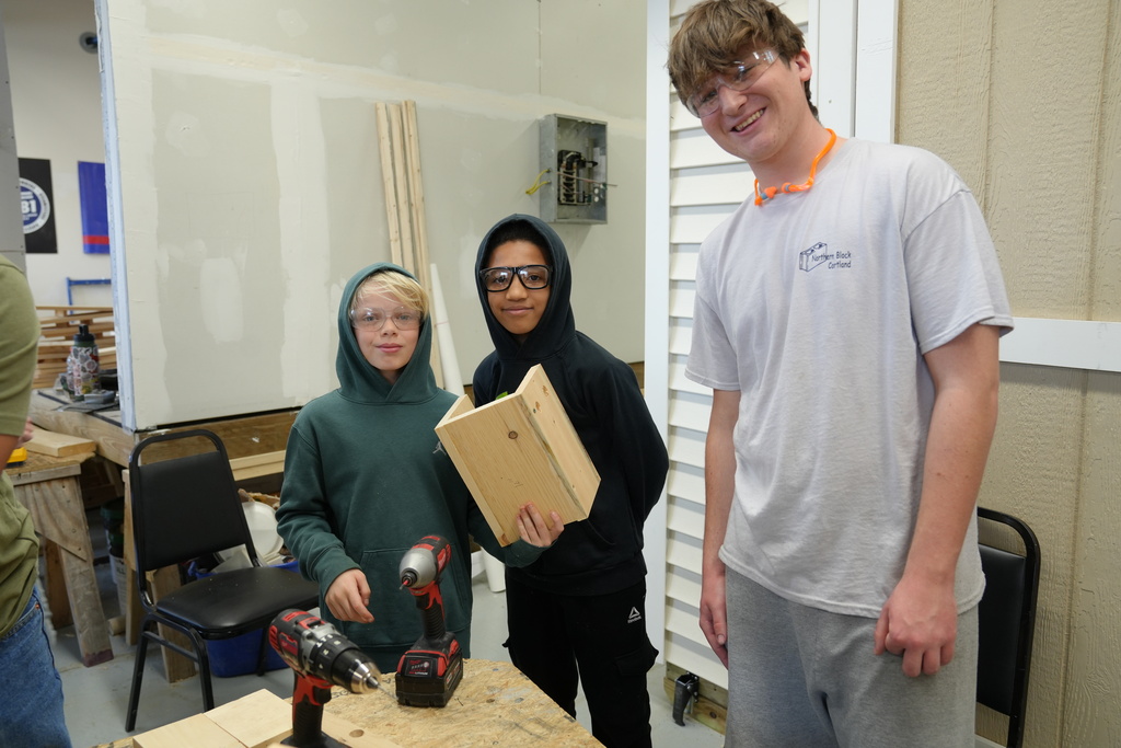 Some students holding up their bird house