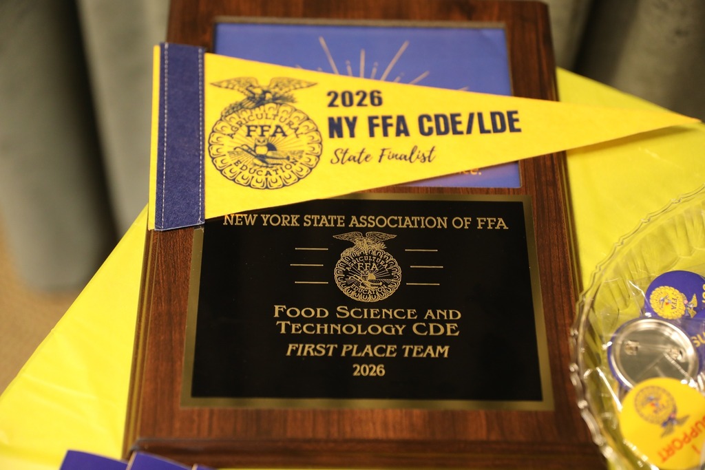 Close-up photo of the 2026 NY FFA Food Science and Technology CDE 1st Place Team plaque and award materials.