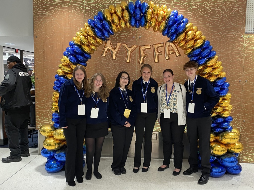 TST BOCES FFA students and advisors pose together under the NY FFA balloon arch at the state convention.