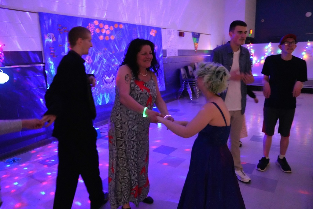 Students and staff dance together under colorful lights during the Under the Sea themed Exceptional Education Prom.