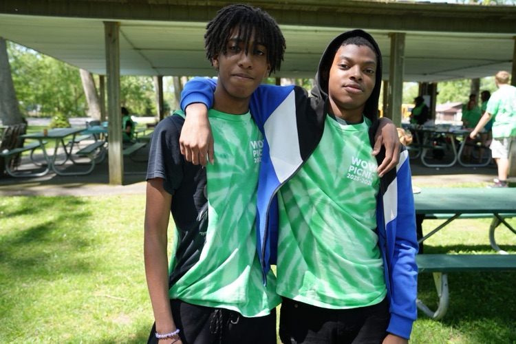 two students pose and smile together at the WOW picnic wearing green tye die shirts