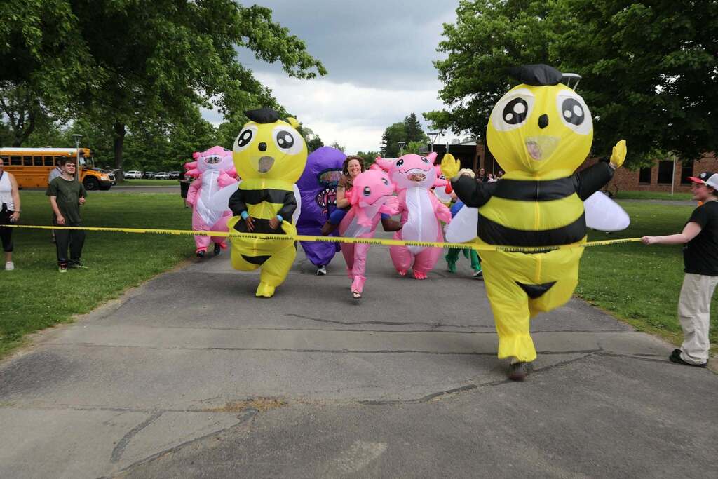 a group of costumed staff members racing as one wins