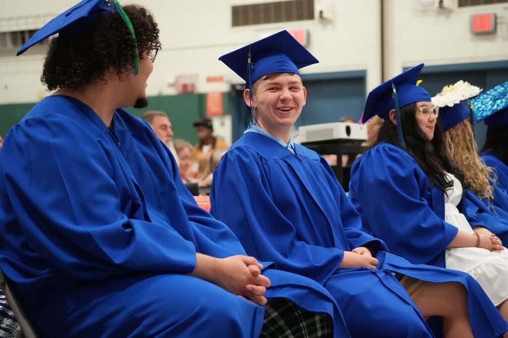 Turning Point graduates share smiles and conversation while seated together before the start of the graduation ceremony.
